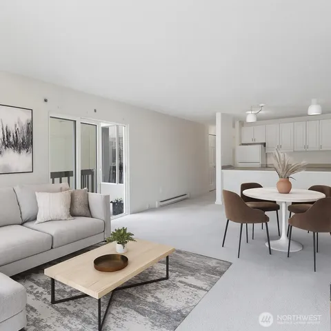 a living room with furniture a rug and kitchen view