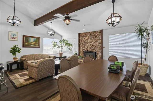 a room with wooden floor pool table and windows