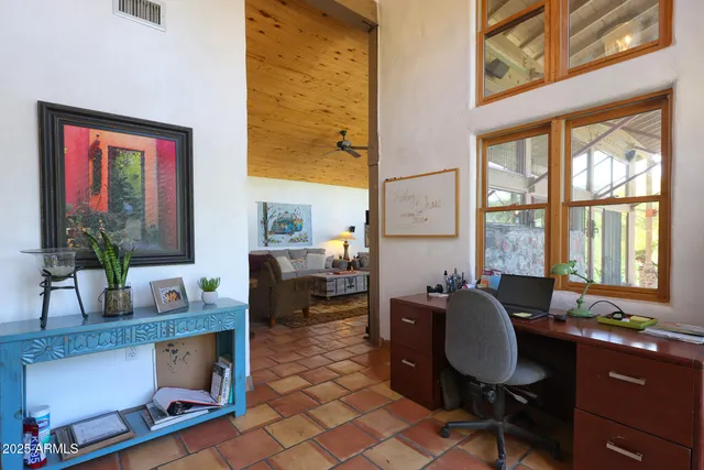 a bedroom with a bed and a dresser next to a window