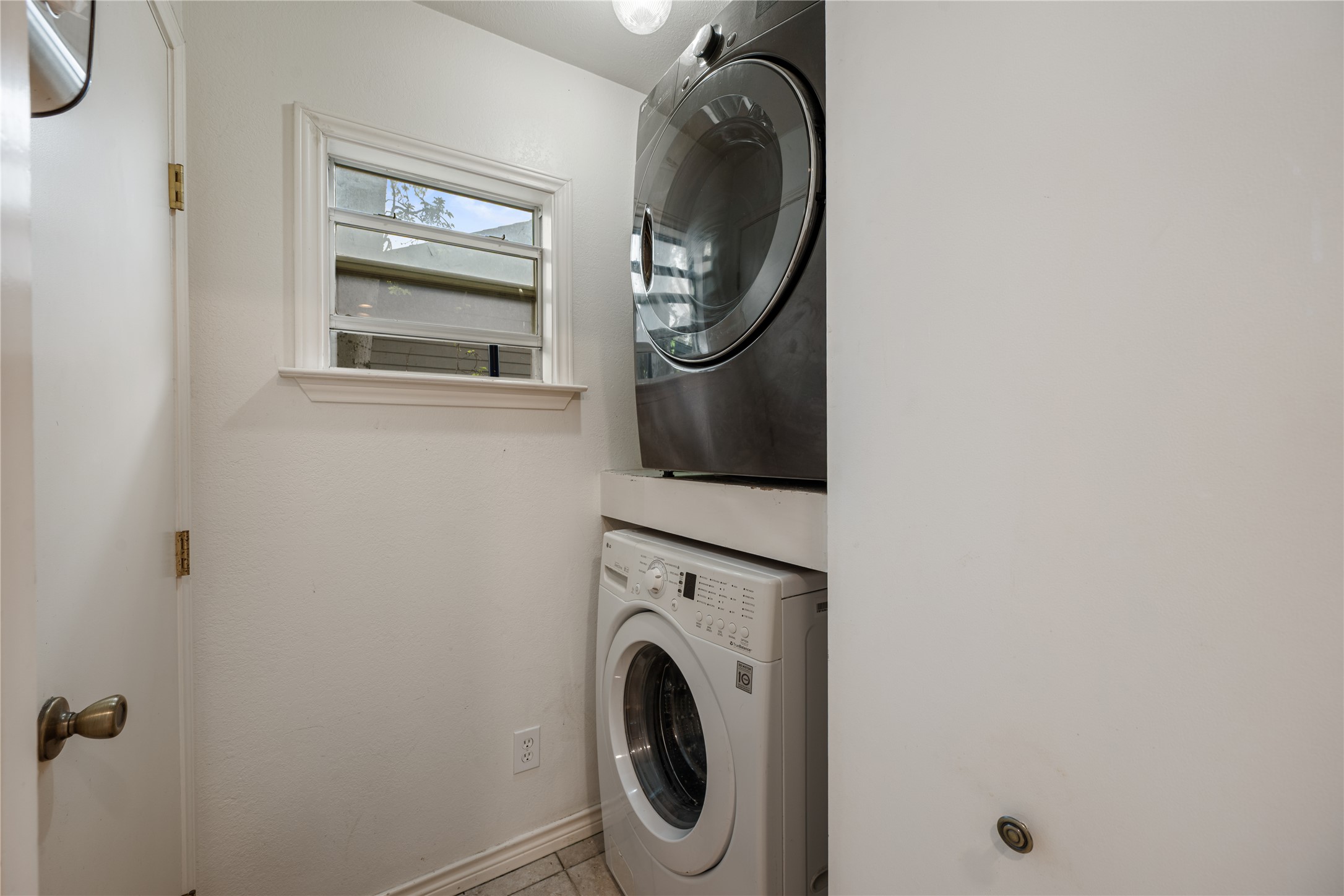 2639 West 45th Street Austin, TX 78731 - Photo 21 of 29 Laundry room with stacked washer and clothes dryer and light tile patterned floors