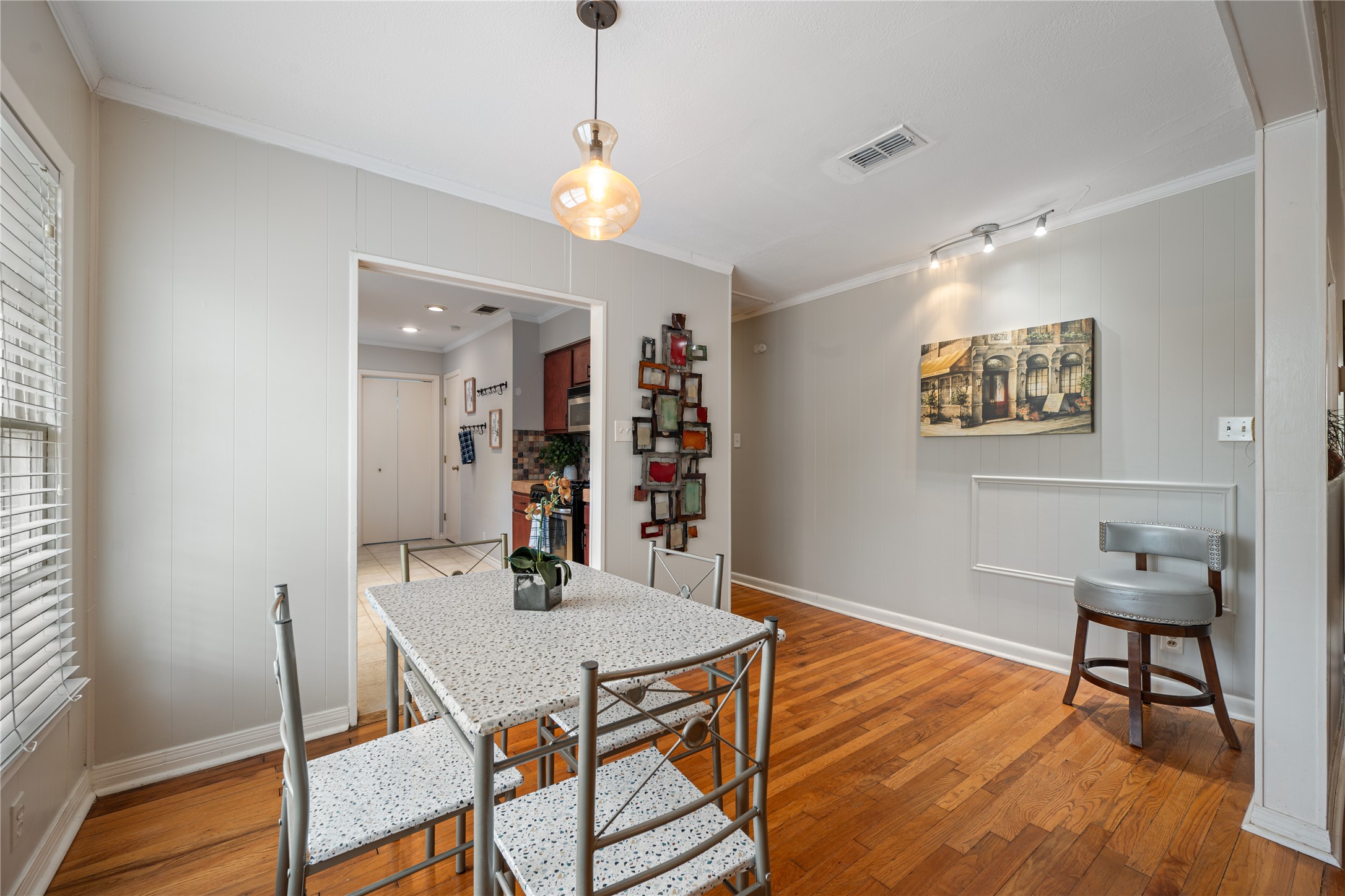 2639 West 45th Street Austin, TX 78731 - Photo 25 of 29 Dining room featuring ornamental molding, light wood finished floors, and wood walls