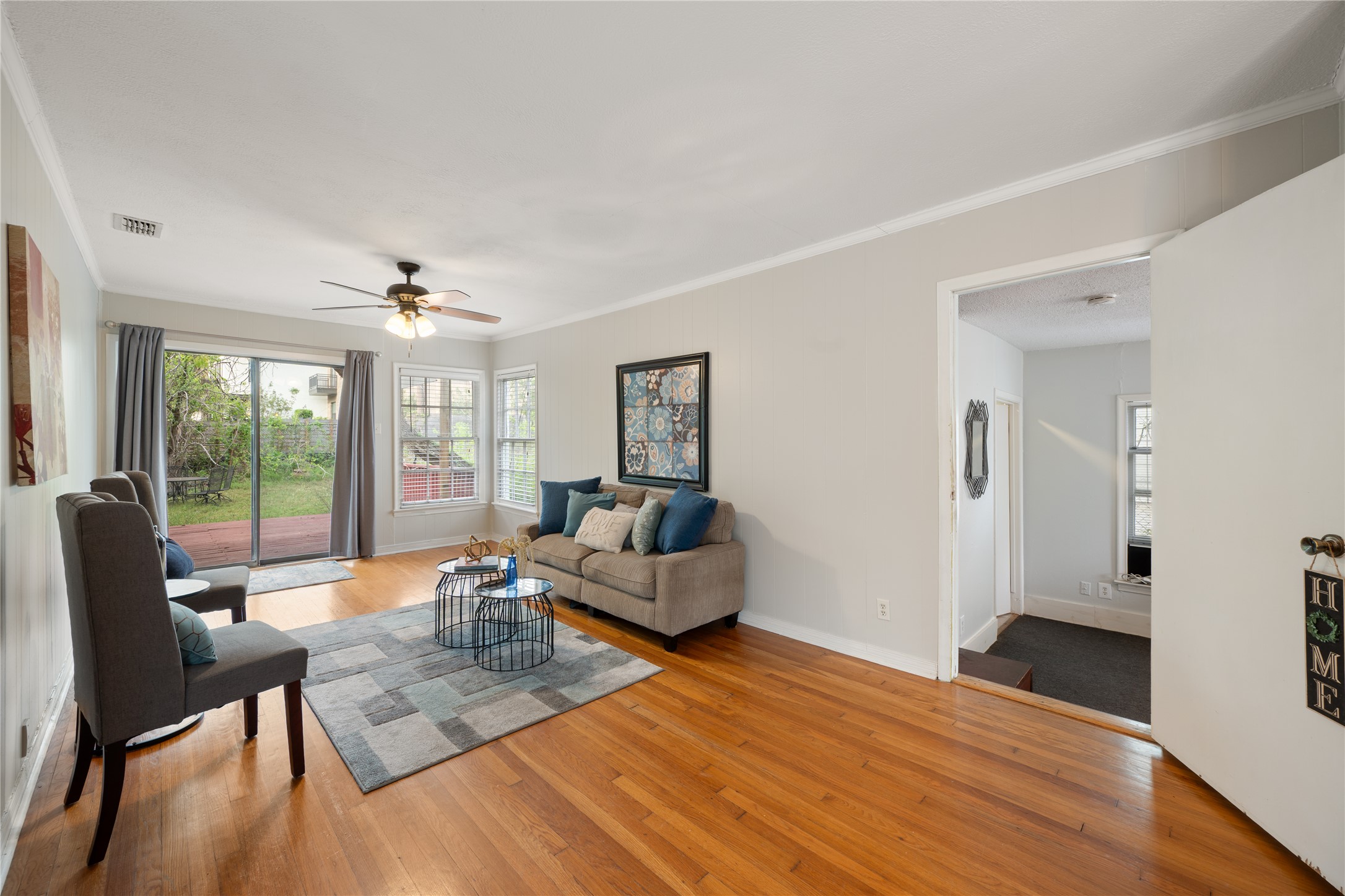 2639 West 45th Street Austin, TX 78731 - Photo 27 of 29 Living room with light wood-style floors, ornamental molding, and a ceiling fan