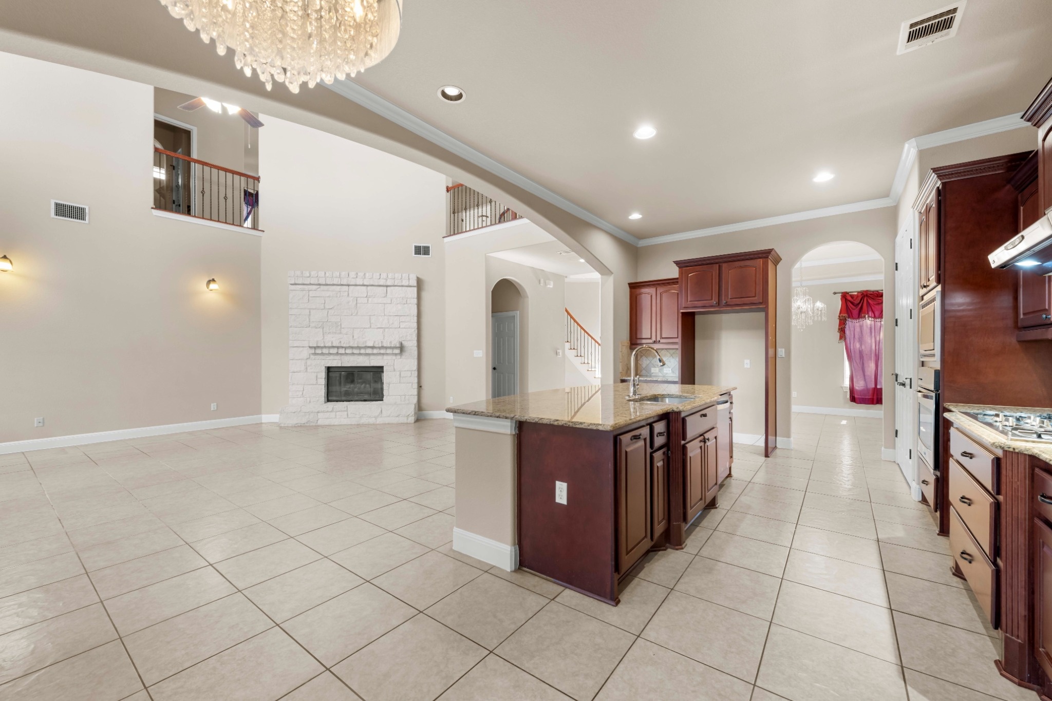 3903 Remington Road Cedar Park, TX 78613 - Photo 8 of 29 A spacious, naturally illuminated living area featuring a central kitchen island and a whitewashed brick fireplace.