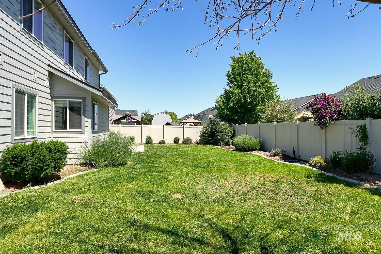846 North Hidden View Way Star, ID 83669 - Photo 47 of 49 Expansive lawn area bordered by a light-colored privacy fence and decorative landscaping