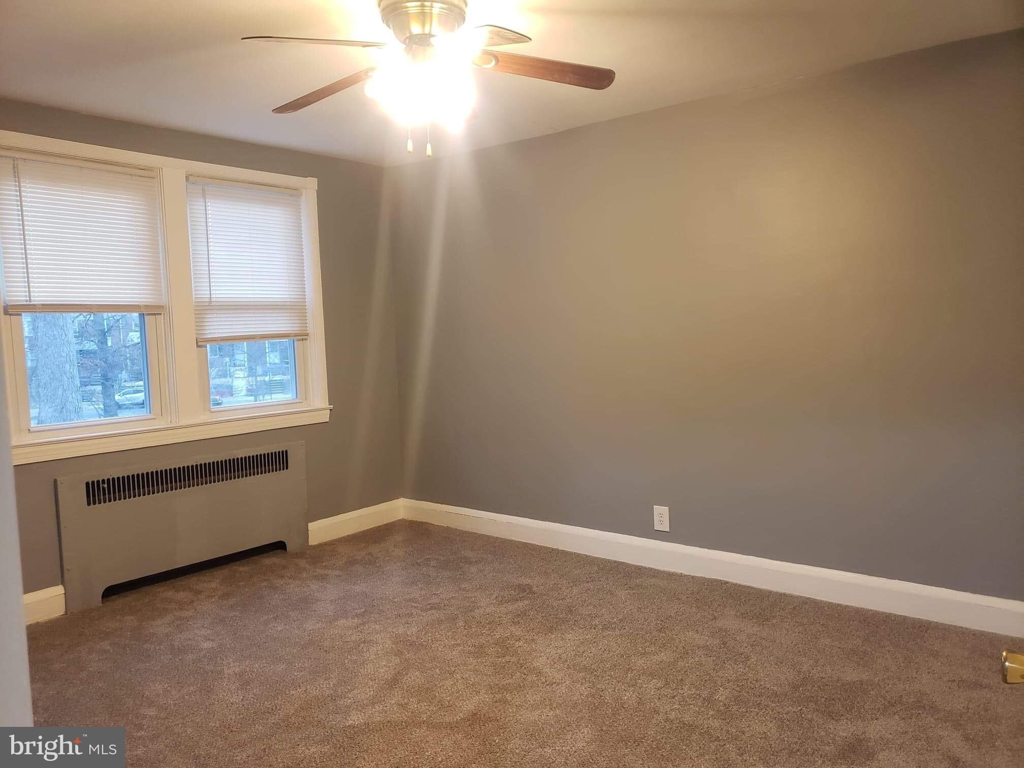 213 Westowne Road Baltimore, MD 21229 - Photo 17 of 20 an empty room with windows and chandelier fan