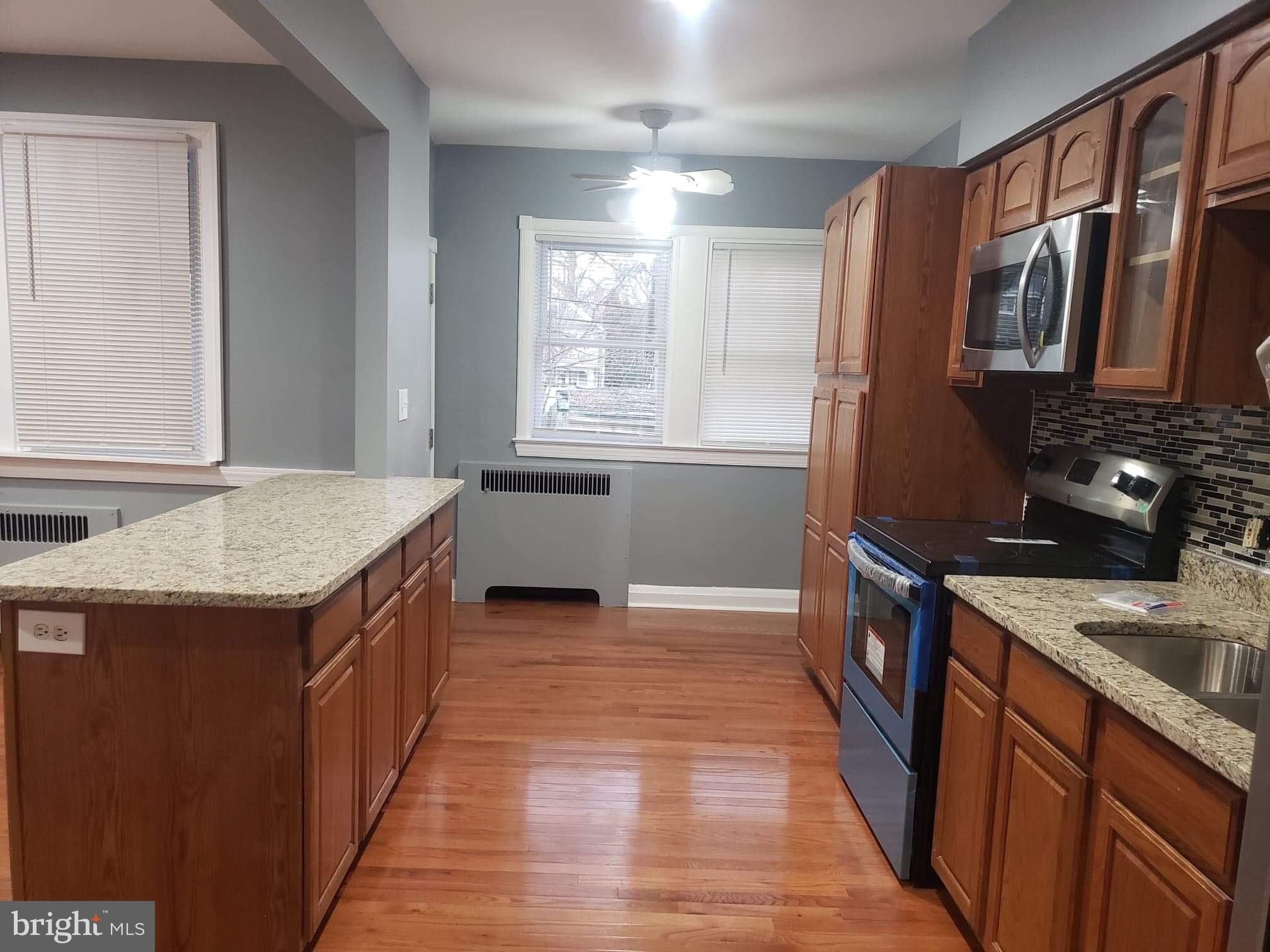 213 Westowne Road Baltimore, MD 21229 - Photo 4 of 20 a kitchen with granite countertop a sink stove and cabinets