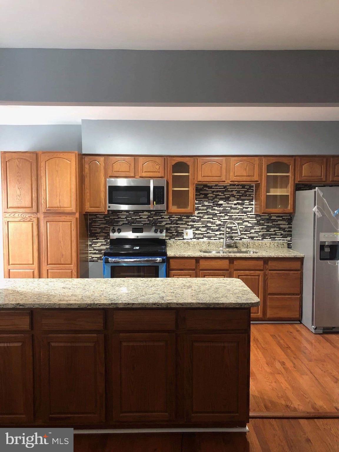 213 Westowne Road Baltimore, MD 21229 - Photo 5 of 20 a kitchen with stainless steel appliances wooden cabinets and a counter top space