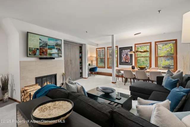 a living room with furniture fireplace and a large window