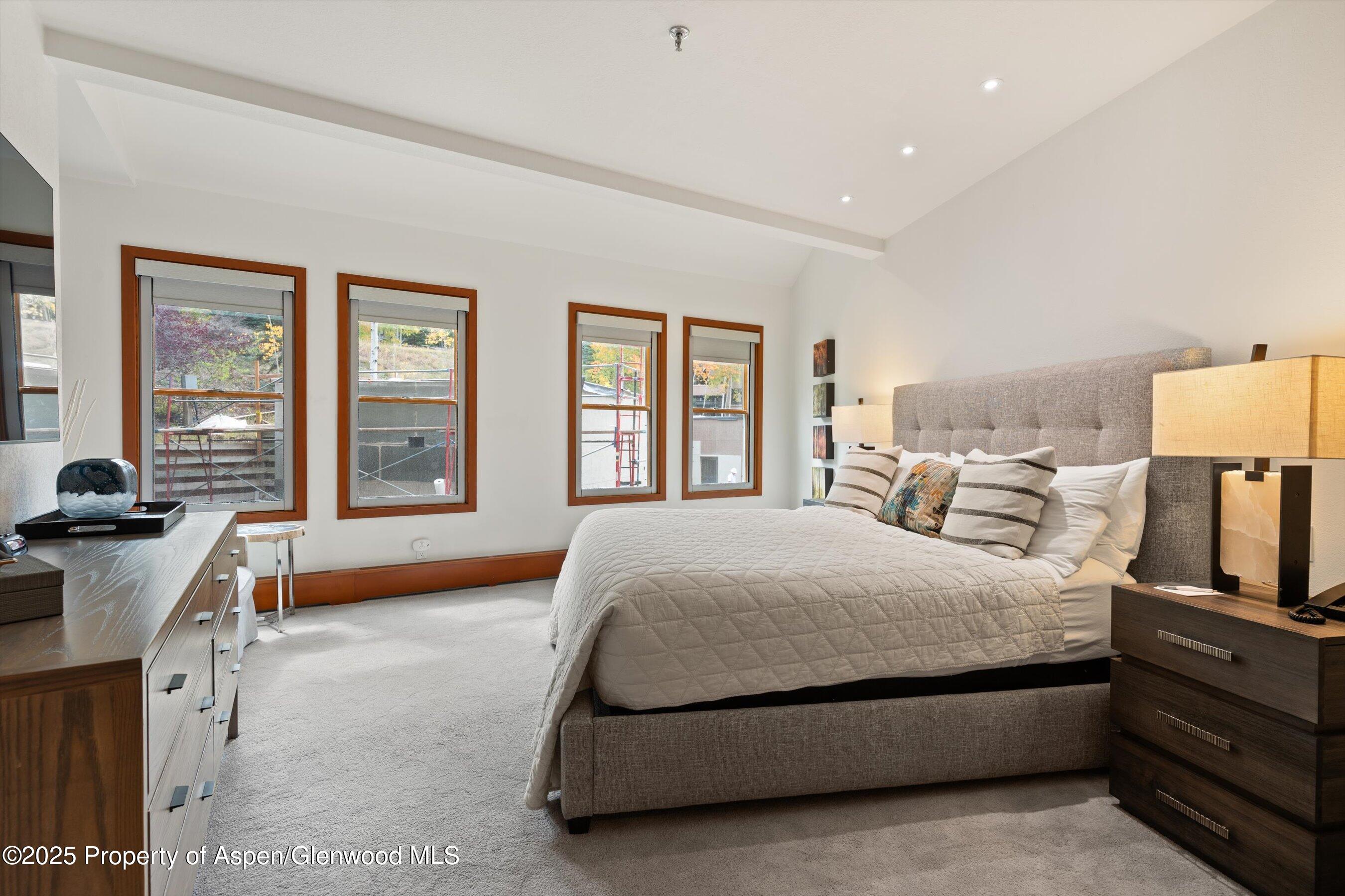 425 Wood Road, Unit 19 Snowmass Village, CO 81615 - Photo 9 of 26 a spacious bedroom with a bed and a cabinets