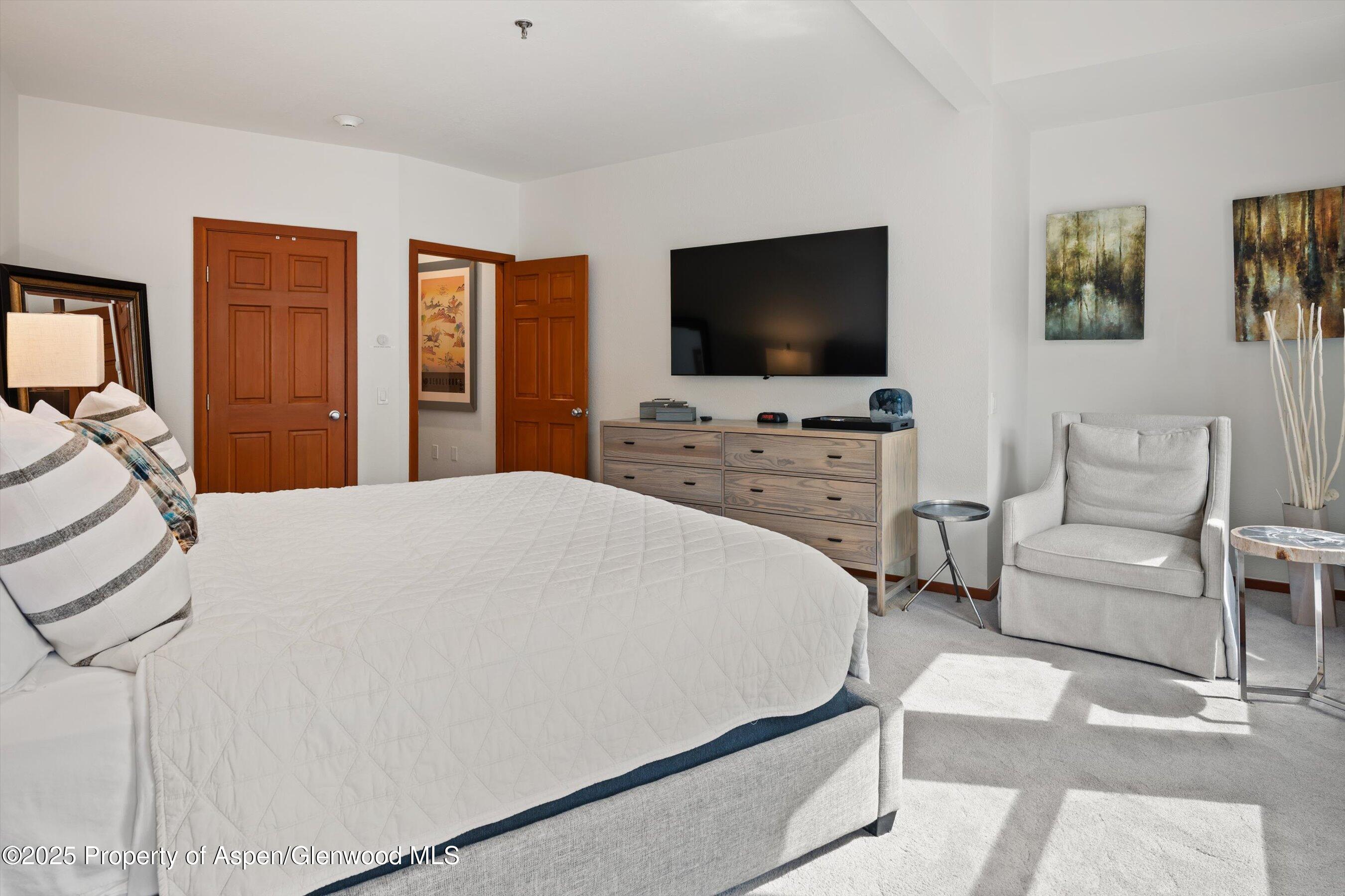 425 Wood Road, Unit 19 Snowmass Village, CO 81615 - Photo 10 of 26 a bedroom with a bed and a flat screen tv