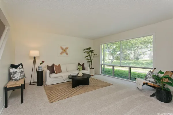 a living room with furniture and a potted plant