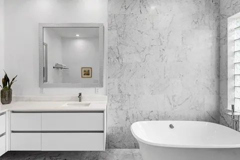 a bathroom with a tub sink and mirror