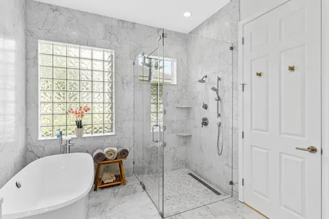 a bathroom with a tub shower and window