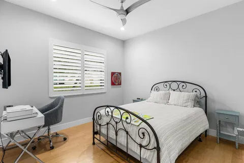 a bedroom with a bed a table and windows