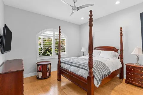 a bedroom with a bed a chandelier and a window