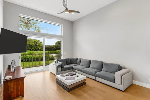 a living room with furniture a flat screen tv and a floor to ceiling window