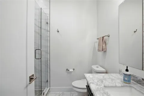 a bathroom with a granite countertop sink mirror vanity and toilet