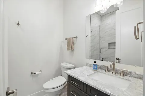 a bathroom with a granite countertop sink toilet and shower