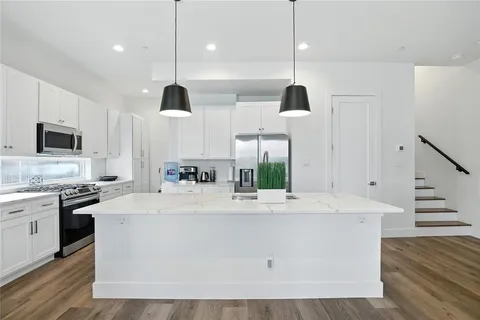 a large white kitchen with stainless steel appliances