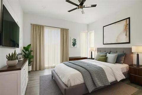 a bedroom with a bed potted plant on the dresser and a window