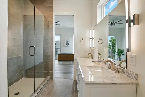 a bathroom with a granite countertop sink a mirror and shower