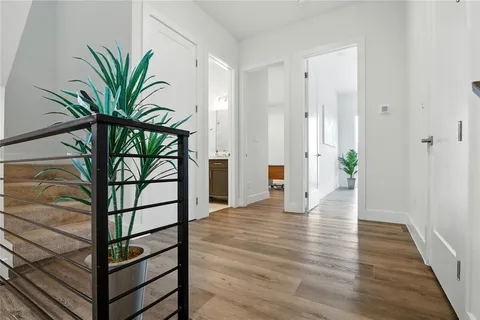 a view of a hallway with wooden floor and a potted plant