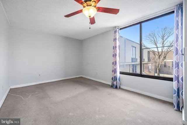 an empty room with closet and a chandelier fan