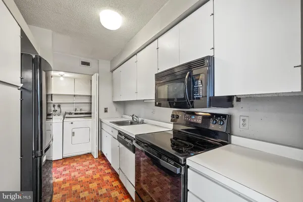 a kitchen with stainless steel appliances a stove microwave and sink