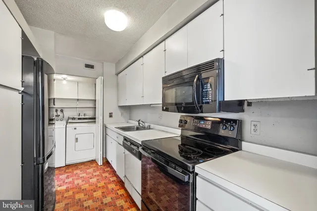 a kitchen with stainless steel appliances a stove microwave and sink