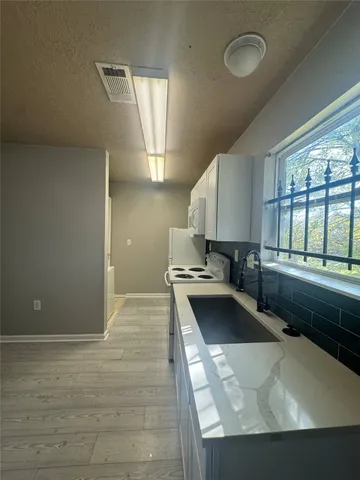 a kitchen with a sink and a stove top oven