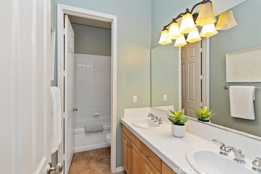 1486 Valley Drive Norco, CA 92860 - Photo 26 of 66 a bathroom with a granite countertop sink a toilet and a mirror