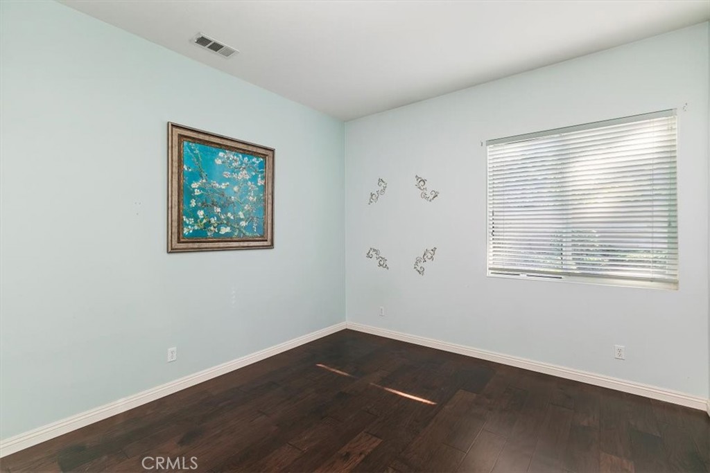 1486 Valley Drive Norco, CA 92860 - Photo 27 of 66 a view of an empty room with wooden floor and a window