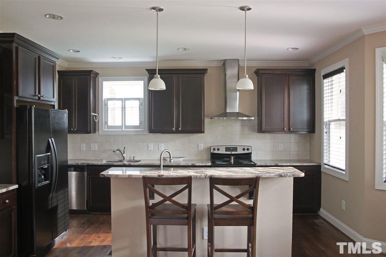 5312 Olive Road Raleigh, NC 27606 - Photo 2 of 5 a kitchen with stainless steel appliances granite countertop a sink a stove a refrigerator cabinets and a window
