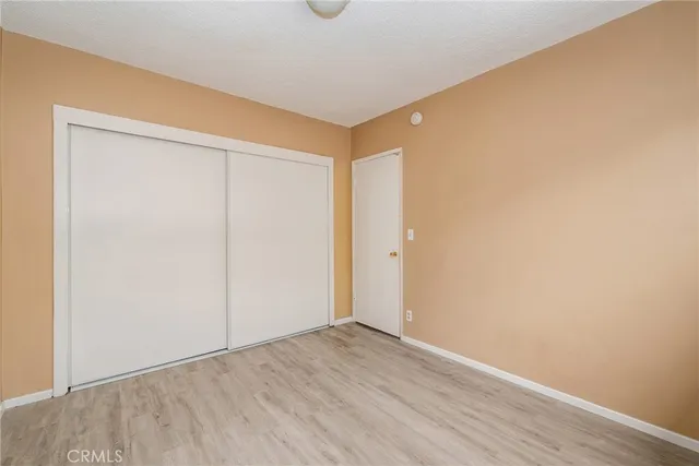 an empty room with wooden floor and closet