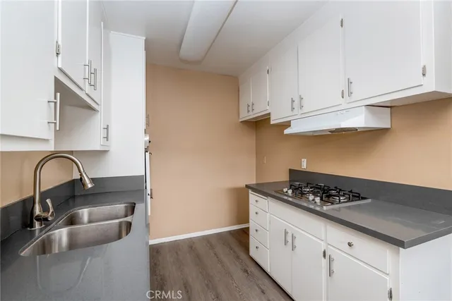 a kitchen with granite countertop a sink stainless steel appliances and cabinets