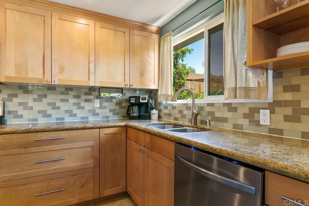 1005 Woodcreek Road Fallbrook, CA 92028 - Photo 13 of 32 a kitchen with stainless steel appliances granite countertop a sink a stove and a wooden cabinets
