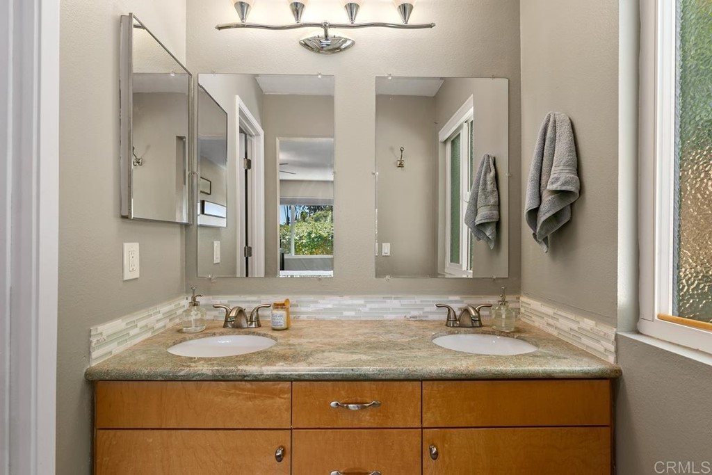 1005 Woodcreek Road Fallbrook, CA 92028 - Photo 18 of 32 a bathroom with a granite countertop sink and a mirror