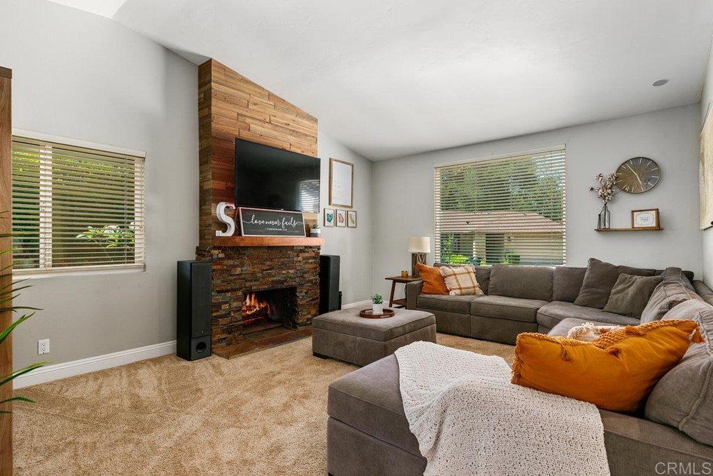 1005 Woodcreek Road Fallbrook, CA 92028 - Photo 7 of 32 a living room with furniture a fireplace and a flat screen tv
