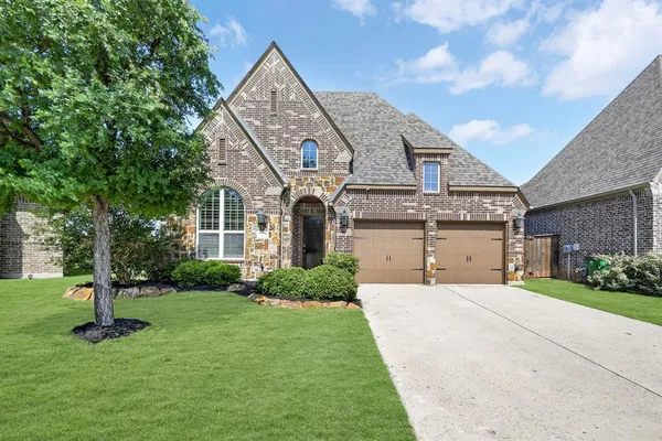 a front view of a house with a yard and garage