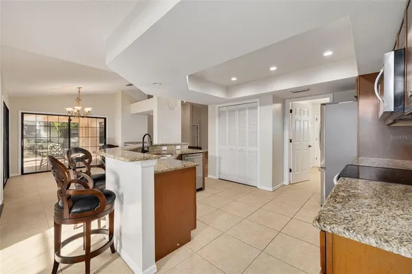 a kitchen with a refrigerator and chairs