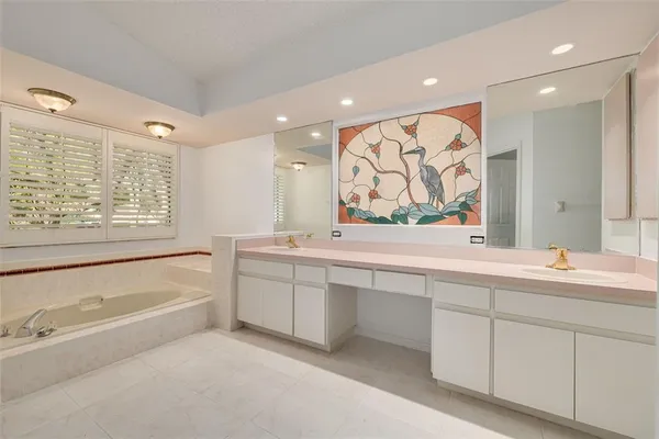 a bathroom with a bathtub sink and large window