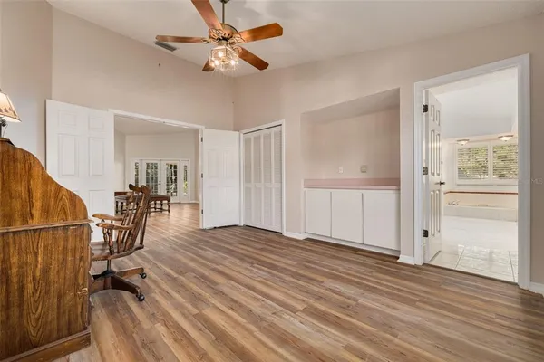 a view of empty room with wooden floor and fan