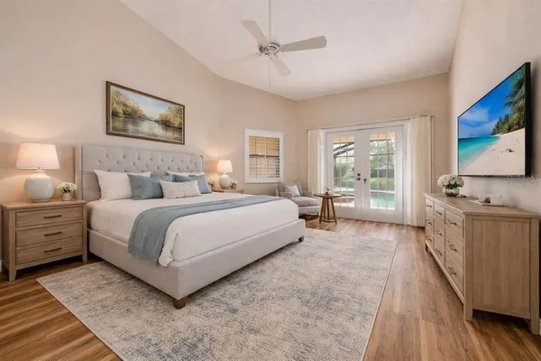 a bedroom with a large bed and a flat tv screen on dresser