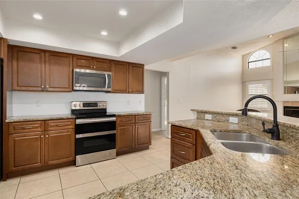 a kitchen with stainless steel appliances granite countertop a stove a sink and a microwave