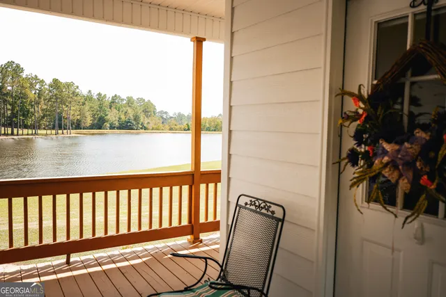 a view of swimming pool with lawn chairs and wooden fence