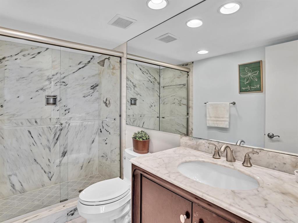 701 East Camino Real, Unit 4E Boca Raton, FL 33432 - Photo 23 of 45 a bathroom with a granite countertop sink a toilet and shower
