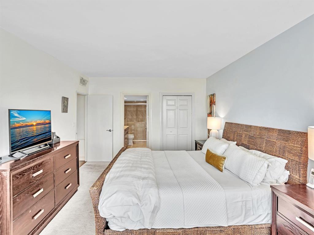 701 East Camino Real, Unit 4E Boca Raton, FL 33432 - Photo 25 of 45 a bedroom with a bed and a flat screen tv
