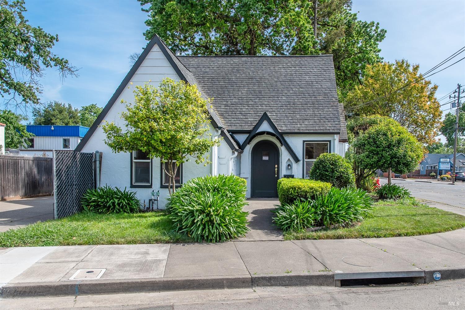 a front view of a house with a yard and potted plants