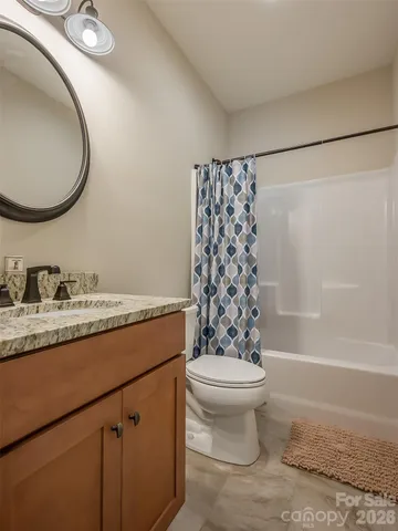 a bathroom with a granite countertop sink toilet mirror vanity and shower