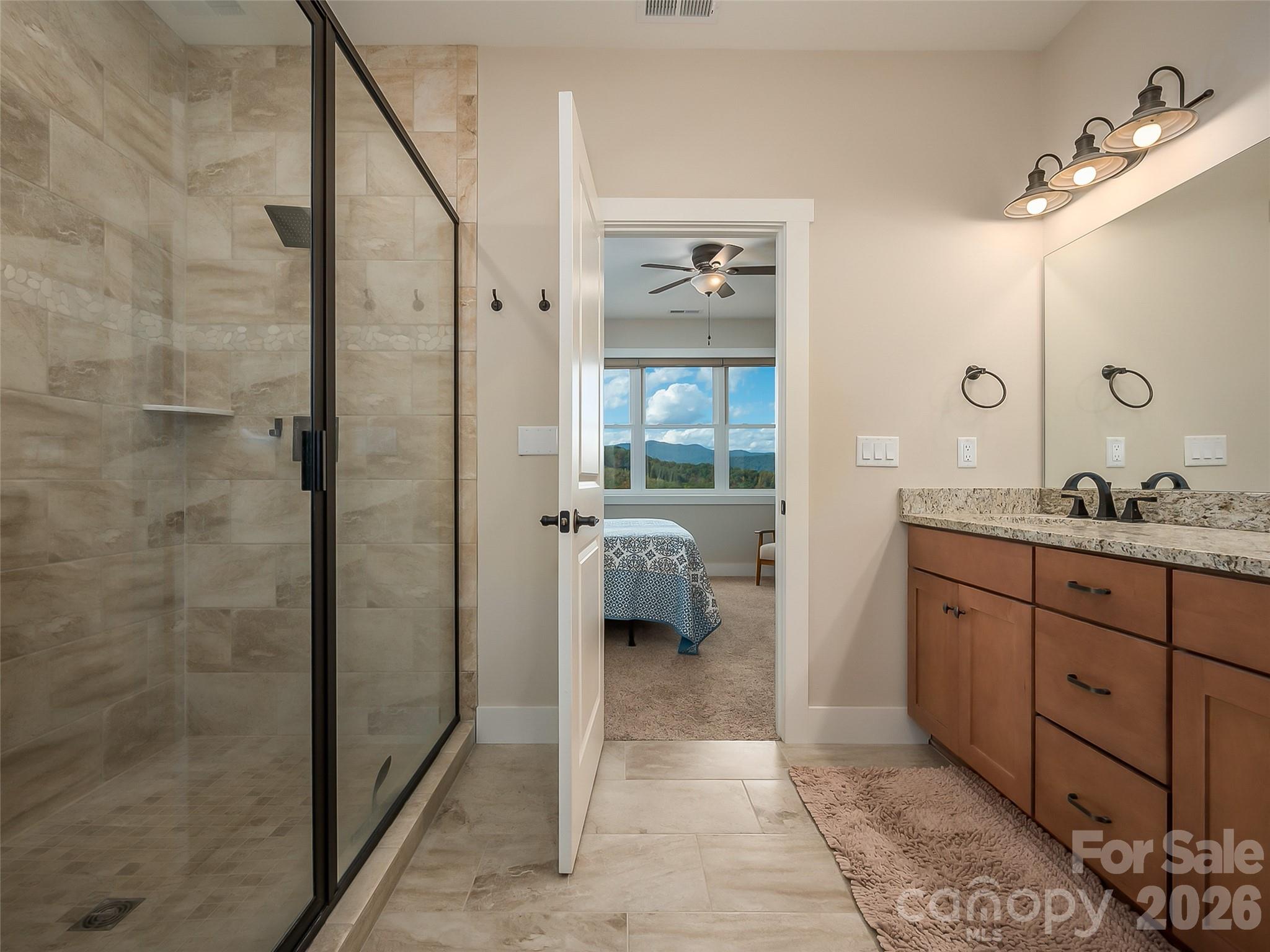 146 Red Hawk Knoll Lake Lure, NC 28746 - Photo 19 of 34 a en suite bathroom with a granite countertop sink a mirror and shower